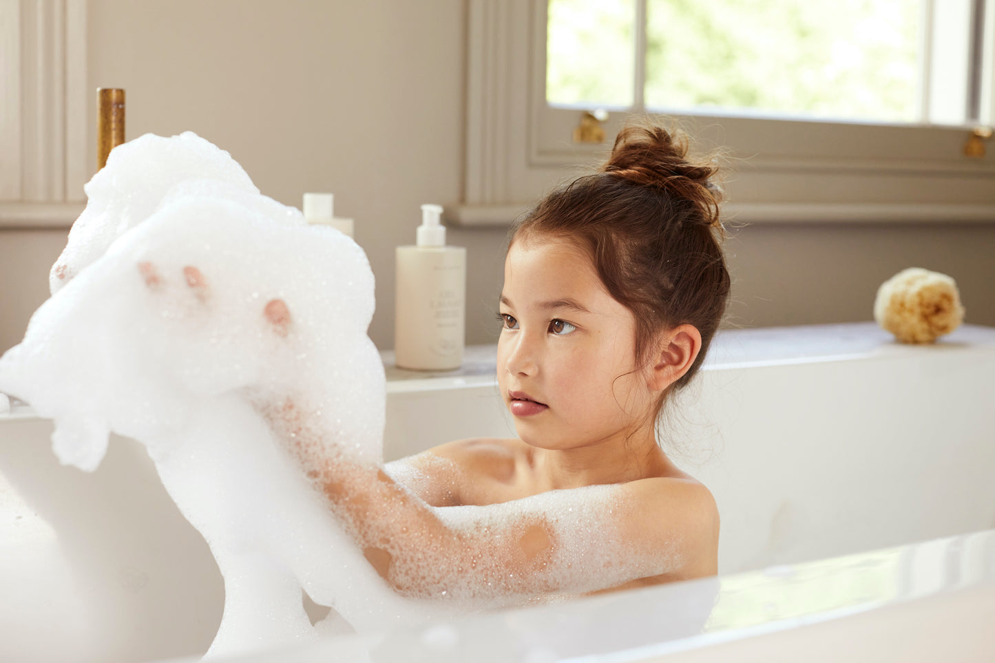 Girl enjoying luxury Belle Enfant baby and child bubble bath from Belle Enfant Beauté collection
