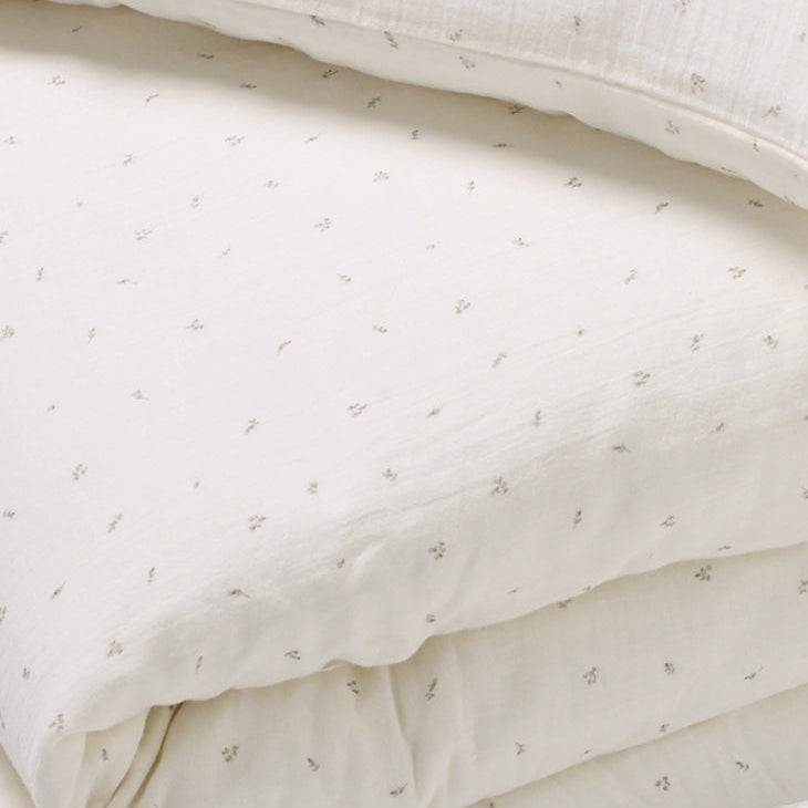 Close up of delicate taupe rosebud print in 100% cotton muslin duvet set for children